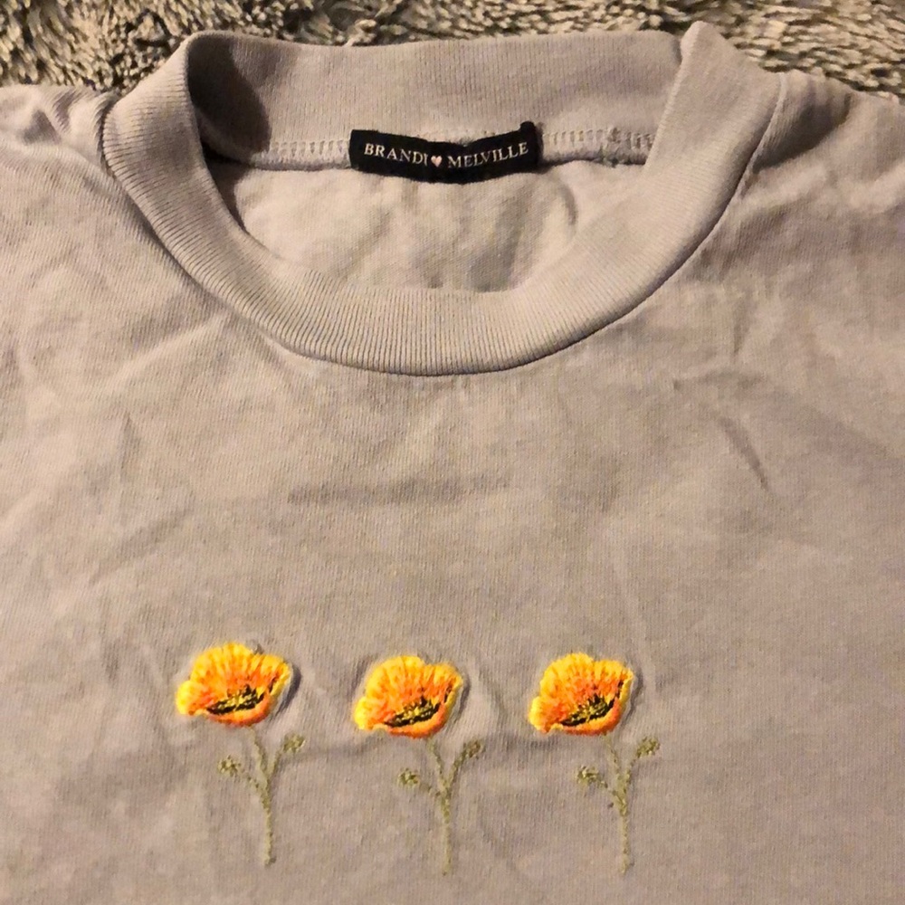 Soft and stretchy cotton tee in white with a 3 flowers embroidered on the chest.